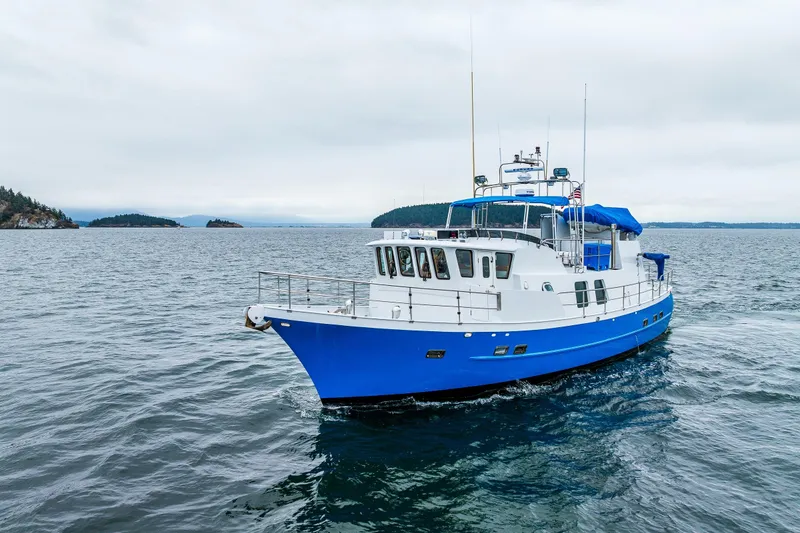 Slide: The Image of Blue and white 1978 Hidden Harbor Custom Trawler cruising on open water. - 10