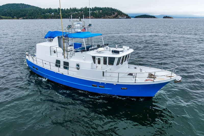 Slide: The Image of 1978 Hidden Harbor Custom Trawler cruising on calm waters with scenic island backdrop. - 14