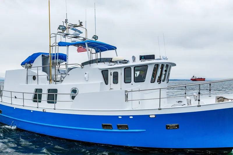Slide: The Image of 1978 Hidden Harbor Custom Trawler with blue hull cruising on open water. - 15