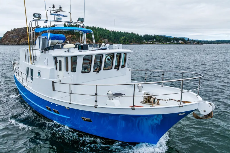 Slide: The Image of 1978 Hidden Harbor Custom Trawler cruising on open water, featuring a blue and white design. - 2