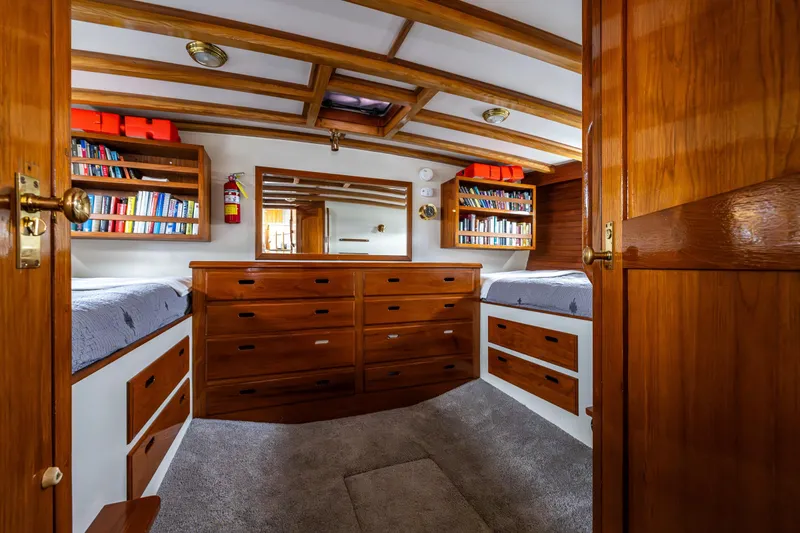 Slide: The Image of 1978 Hidden Harbor Custom Trawler cabin with wooden interior, bookshelves, and twin beds. - 23