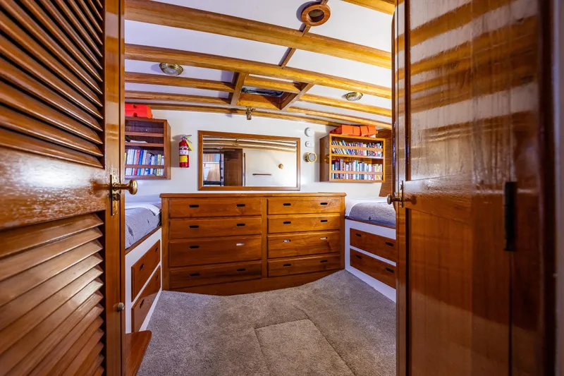 Slide: The Image of Cozy 1978 Hidden Harbor Custom Trawler cabin with wooden drawers, bookshelves, and carpeted floor. - 24