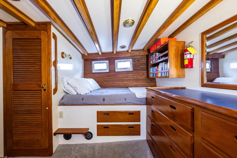 Slide: The Image of Cozy 1978 Hidden Harbor Custom Trawler cabin with wooden interior, bed, and storage. - 26