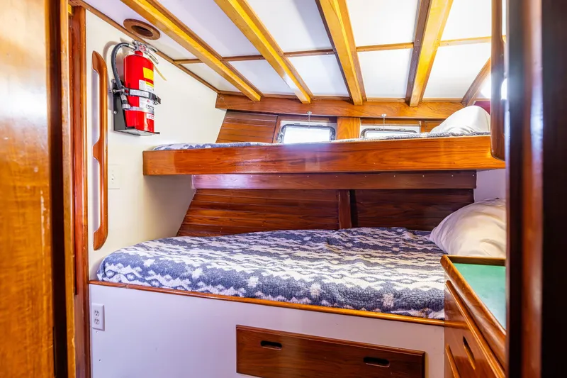 Slide: The Image of Cozy cabin interior of 1978 Hidden Harbor Custom Trawler with wooden bunk beds and fire extinguisher. - 29