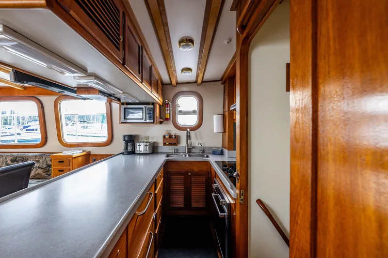 Slide: The Image of 1978 Hidden Harbor Custom Trawler kitchen with wooden cabinetry and modern appliances. - 38