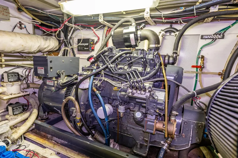 Slide: The Image of Engine room of a 1978 Hidden Harbor Custom Trawler, showcasing detailed machinery and wiring. - 48