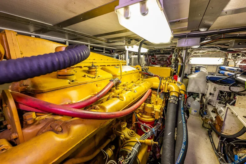 Slide: The Image of Engine room of 1978 Hidden Harbor Custom Trawler with yellow machinery and cables. - 49