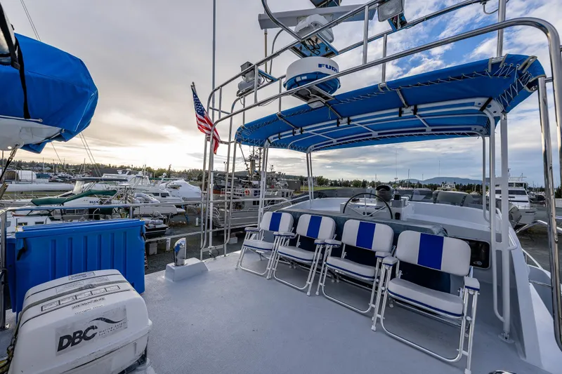 Slide: The Image of 1978 Hidden Harbor Custom Trawler with blue canopy and seating, docked at marina. - 50