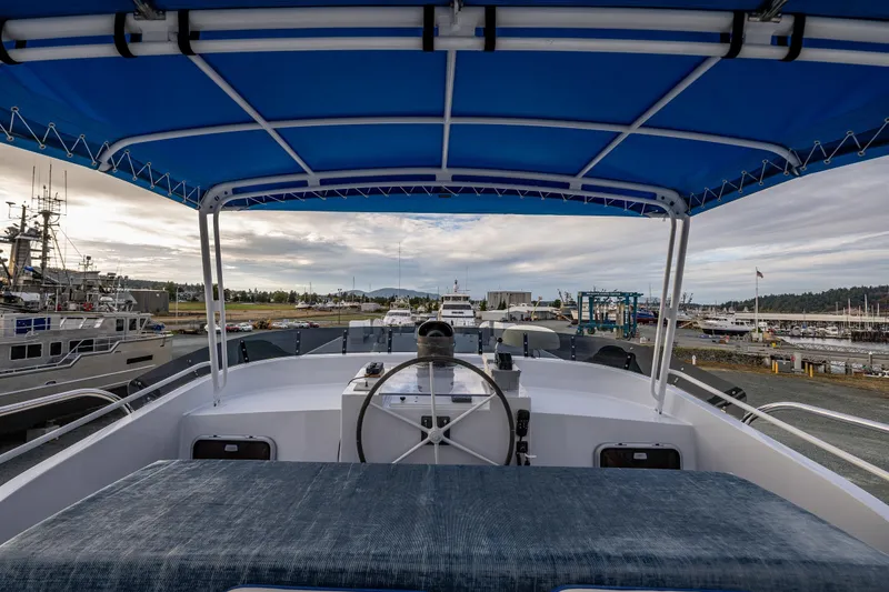 Slide: The Image of 1978 Hidden Harbor Custom Trawler with blue canopy, docked at a marina. - 51