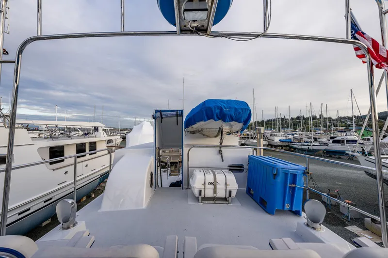 Slide: The Image of 1978 Hidden Harbor Custom Trawler docked at marina, featuring deck equipment and American flag. - 53