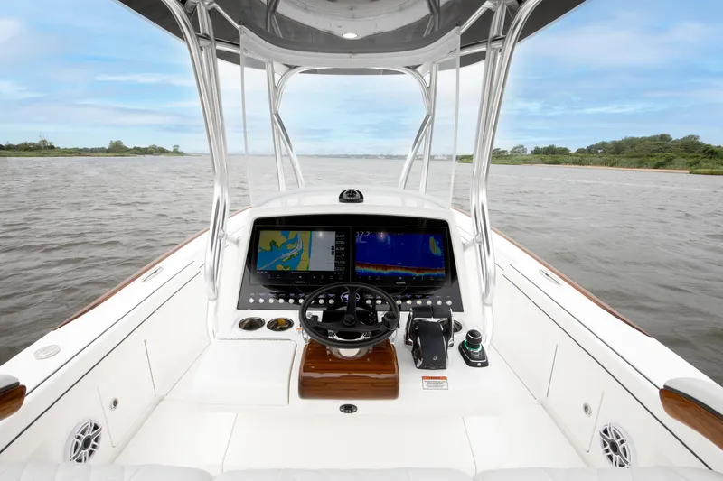 Slide: The Image of 2026 Valhalla Boatworks V-29 Hybrid dashboard with navigation screens on open water. - 9
