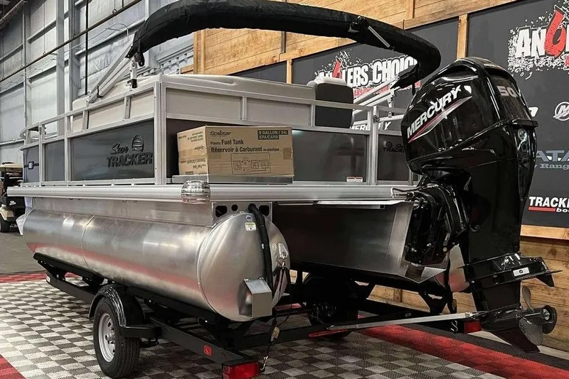 Slide: The Image of 2026 Sun Tracker Bass Buggy® 16 XL Select pontoon boat with Mercury outboard motor in showroom. - 3