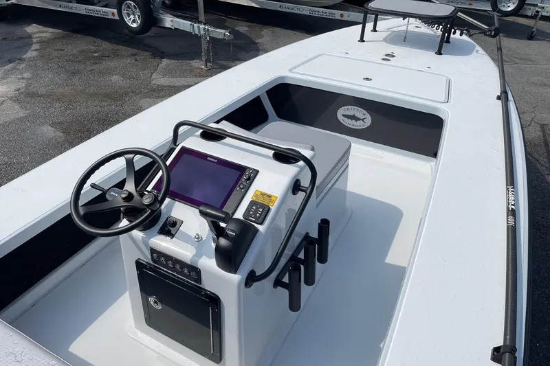 Slide: The Image of 2026 Chittum Skiffs Islamorada 21 boat console with steering wheel and navigation display. - 13