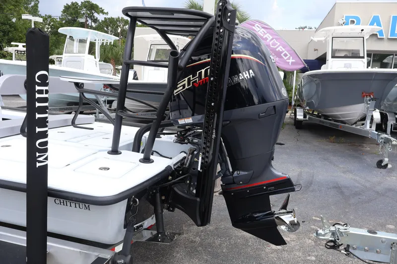 Slide: The Image of 2026 Chittum Skiffs Islamorada 21 with Yamaha outboard motor in a boat dealership. - 20