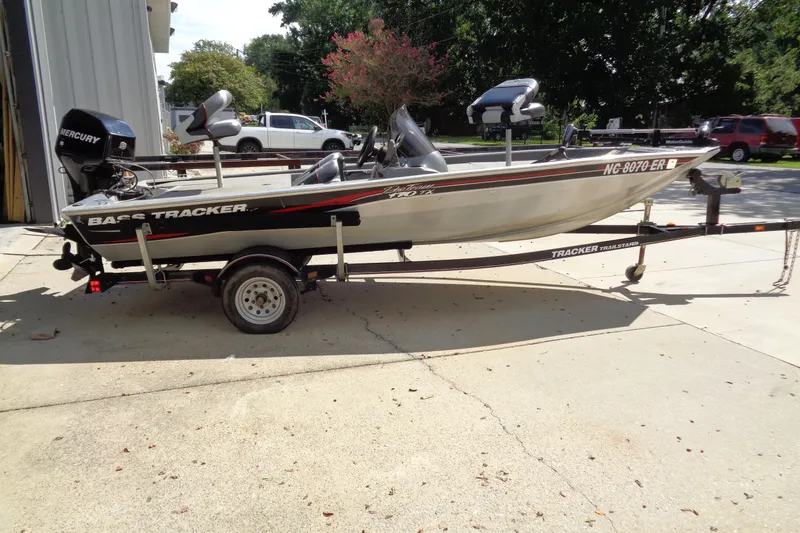 Slide: The Image of 2006 Bass Tracker PT175 boat on trailer, parked outdoors, featuring Mercury engine. - 2