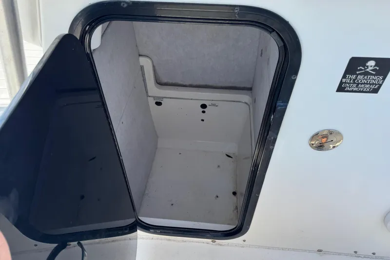 Slide: The Image of Open storage compartment on 2000 Regulator 26 Center Console boat. - 11