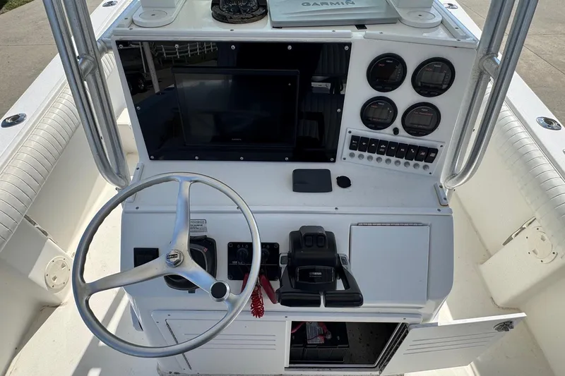 Slide: The Image of 2000 Regulator 26 Center Console boat dashboard with steering wheel and gauges. - 16