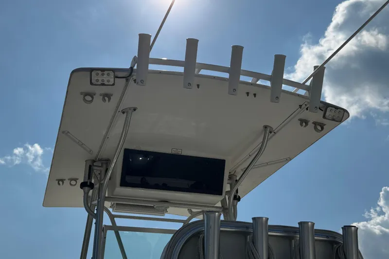 Slide: The Image of 2000 Regulator 26 Center Console boat top view with rod holders and clear sky. - 26