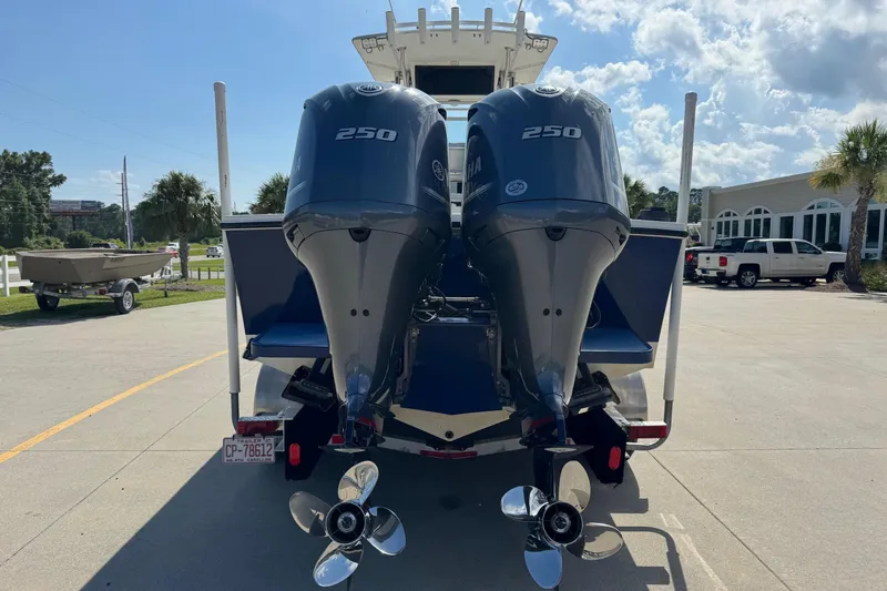 Slide: The Image of 2000 Regulator 26 Center Console boat with twin Yamaha 250 engines, parked outdoors. - 3