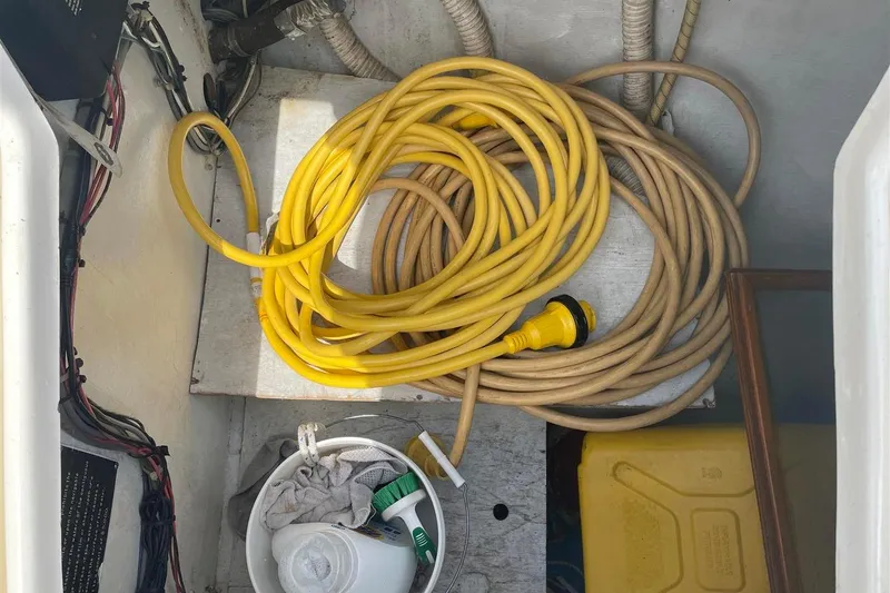 Slide: The Image of Storage compartment of 1986 J Boats J/28 with coiled yellow and beige cables. - 13