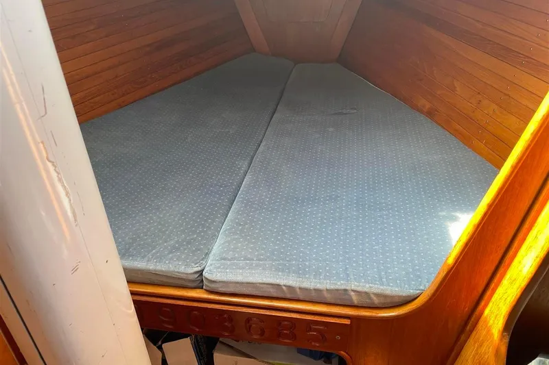 Slide: The Image of 1986 J Boats J/28 interior cabin with wooden walls and cushioned berth. - 17