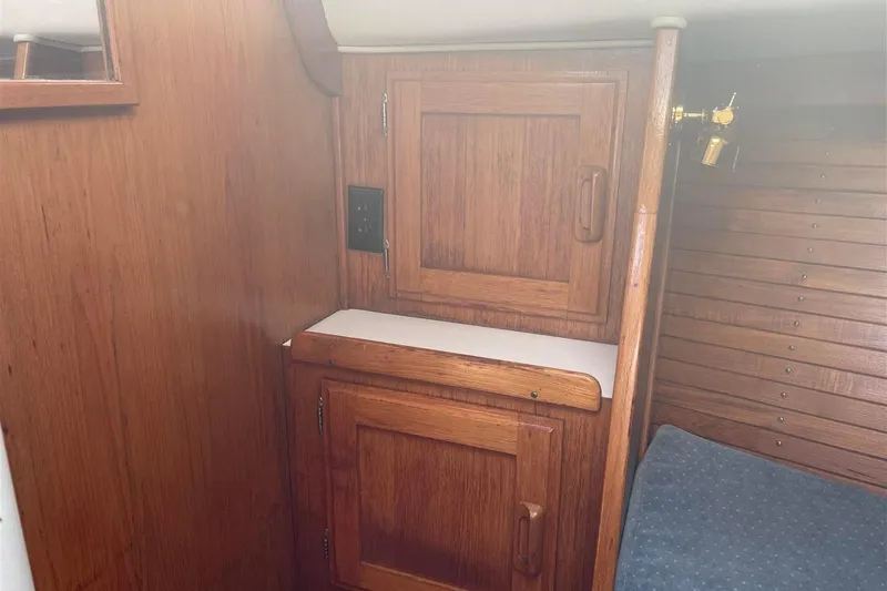 Slide: The Image of Interior of 1986 J Boats J/28 sailboat with wooden cabinetry and blue upholstery. - 19