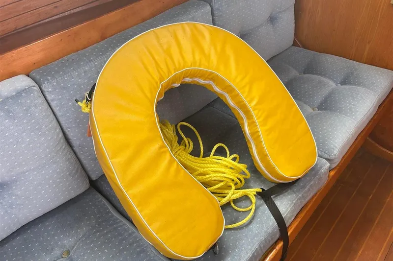 Slide: The Image of Yellow life preserver on a cushioned seat inside a 1986 J Boats J/28 sailboat. - 21