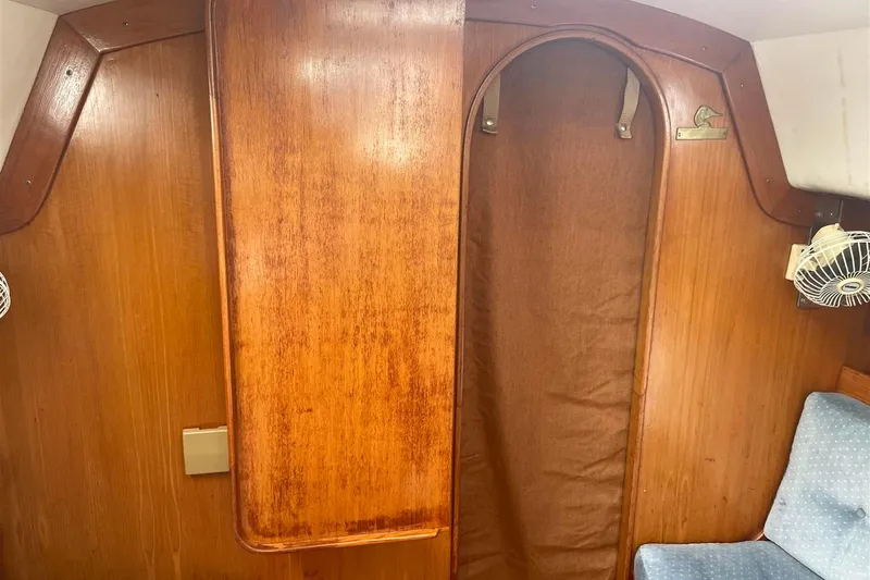 Slide: The Image of Interior of 1986 J Boats J/28 sailboat with wooden paneling and blue seating. - 22