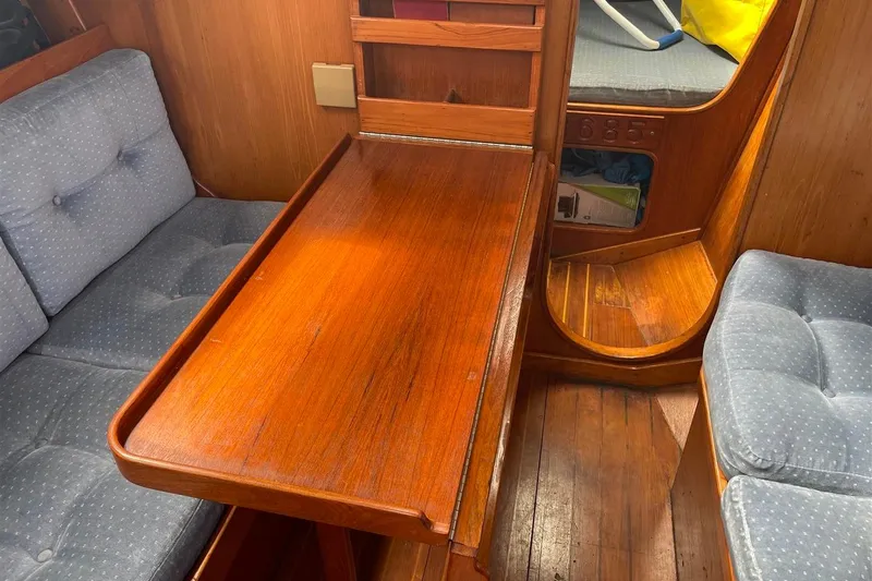 Slide: The Image of Interior of 1986 J Boats J/28 sailboat with wooden table and cushioned seating. - 23