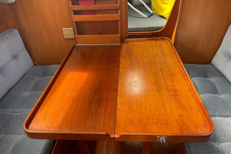 Slide: The Image of 1986 J Boats J/28 interior with wooden table and cushioned seating. - 24