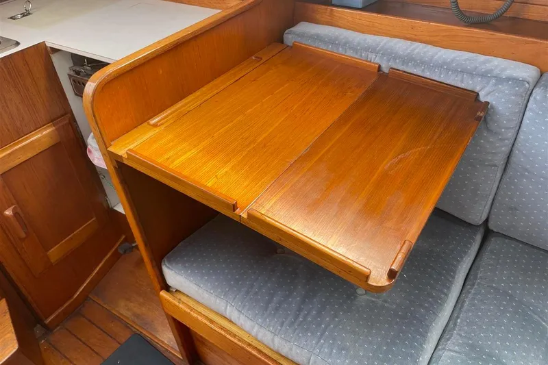 Slide: The Image of 1986 J Boats J/28 interior with wooden foldable table and cushioned seating. - 35