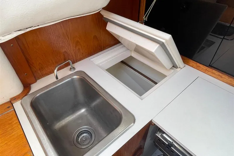 Slide: The Image of 1986 J Boats J/28 yacht galley with stainless steel sink and storage compartment. - 37