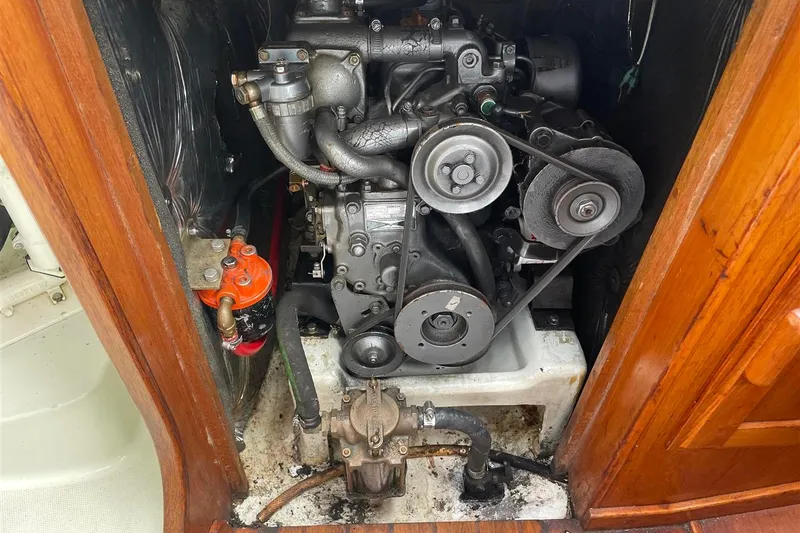 Slide: The Image of Engine compartment of a 1986 J Boats J/28 sailboat, showcasing mechanical components and belts. - 39