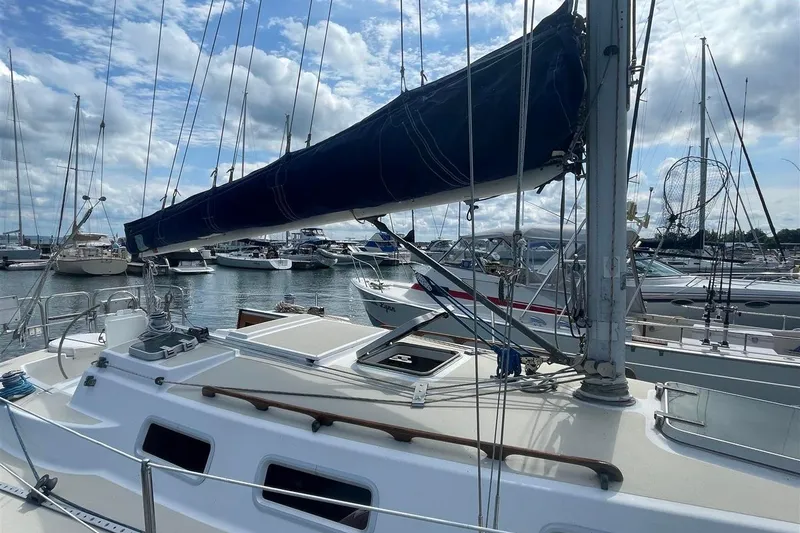 Slide: The Image of 1986 J Boats J/28 sailboat docked in a marina under a cloudy sky. - 4