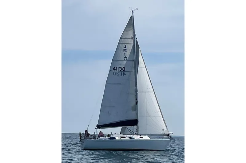 Slide: The Image of 1986 J Boats J/28 sailboat on open water, full sails, clear sky. - 41