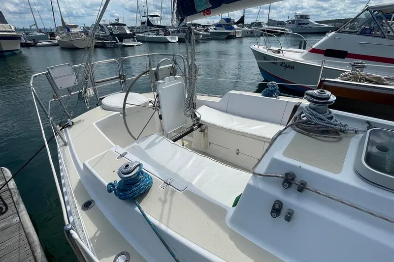 Slide: The Image of 1986 J Boats J/28 sailboat docked in marina, featuring spacious cockpit and rigging. - 5
