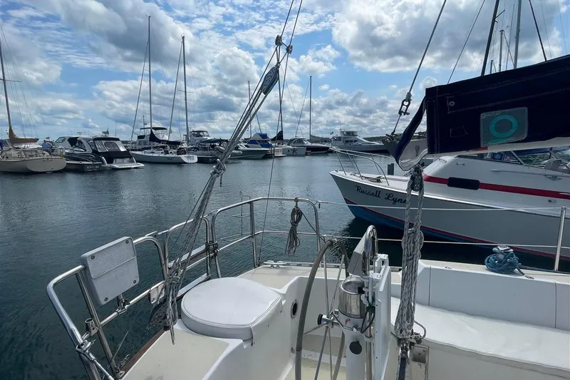 Slide: The Image of 1986 J Boats J/28 sailboat docked in a marina with other vessels. - 6