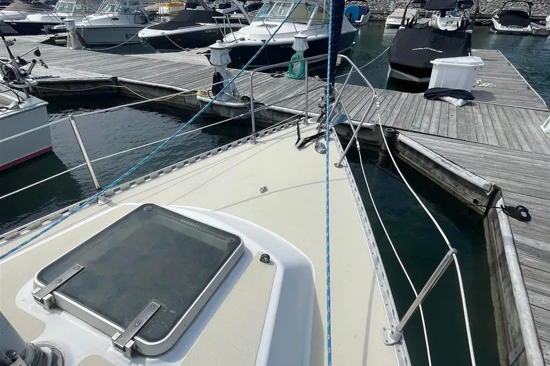 Slide: The Image of 1986 J Boats J/28 sailboat docked at marina, showing deck and hatch. - 7