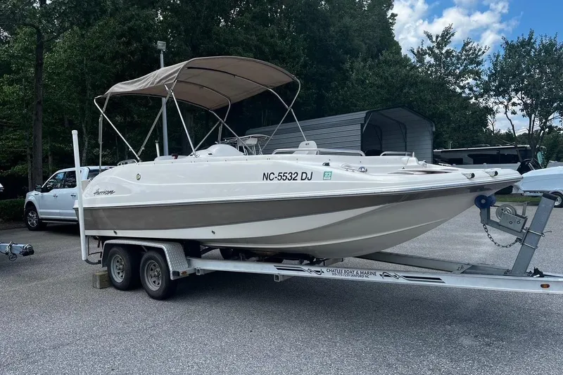 Slide: The Image of 2008 Hurricane FD202 boat on trailer, parked outdoors with trees in background. - 2