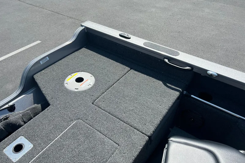 Slide: The Image of 2024 Crestliner 1850 Fish Hawk boat interior with carpeted deck and storage compartments. - 12