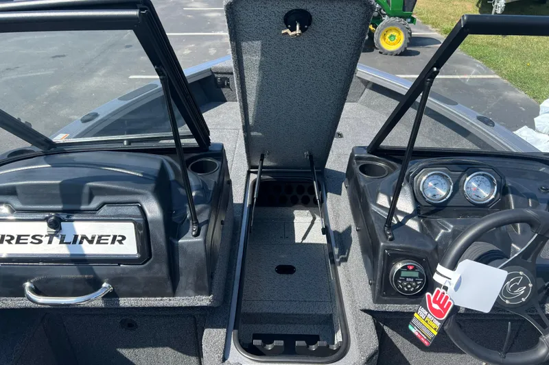 Slide: The Image of 2024 Crestliner 1850 Fish Hawk boat interior with open storage and dashboard gauges. - 6