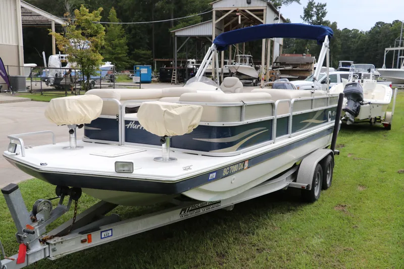 Slide: The Image of 2014 Hurricane FunDeck 226 boat on trailer, parked outdoors near a marina. - 1