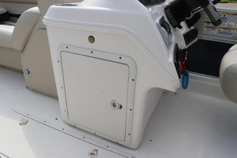 Slide: The Image of 2014 Hurricane FunDeck 226 boat interior with steering console and storage compartment. - 19