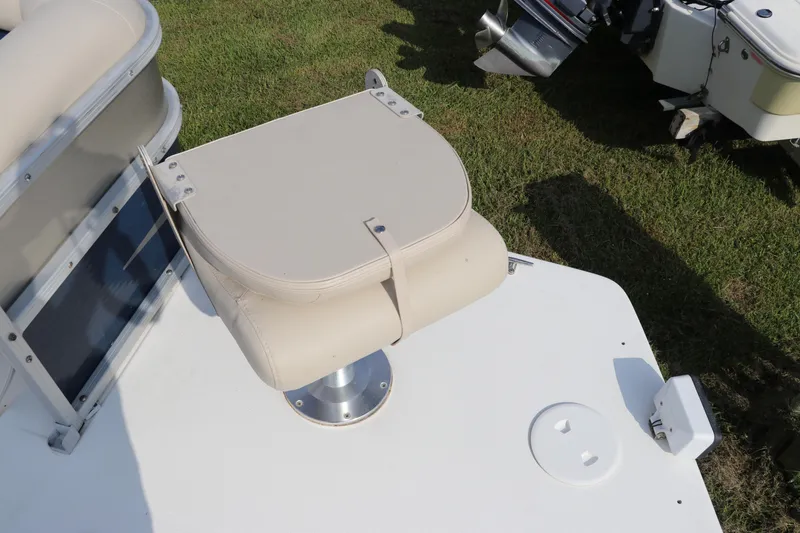 Slide: The Image of 2014 Hurricane FunDeck 226 boat seat on grassy area, showcasing beige upholstery. - 37
