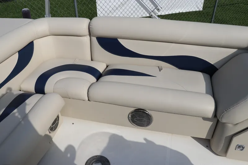 Slide: The Image of 2014 Hurricane FunDeck 226 boat interior with beige and navy seating, speaker, and cup holder. - 7