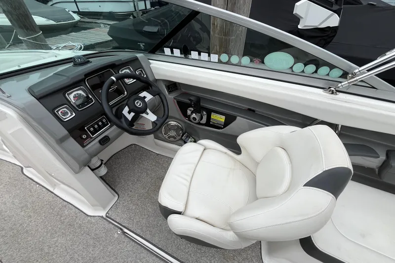 Slide: The Image of 2013 Chaparral 226 SSi Wide Tech boat interior with steering wheel and white captain's chair. - 10