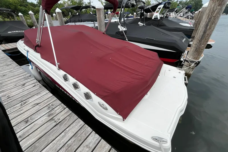 Slide: The Image of 2013 Chaparral 226 SSi Wide Tech boat with maroon cover docked at marina. - 2