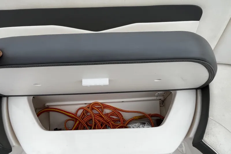 Slide: The Image of 2013 Chaparral 226 SSi Wide Tech boat storage compartment with ropes inside. - 21