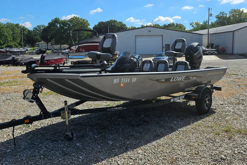 Slide: The Image of 2015 Lowe Stinger 175 boat on trailer, parked outdoors under clear sky. - 4