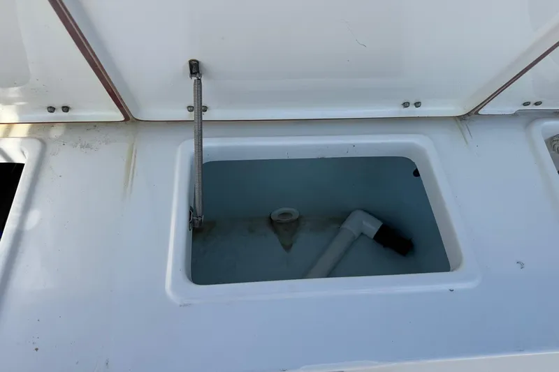 Slide: The Image of Open storage compartment on 2012 Sea Hunt Triton 225 boat, showing interior details. - 19